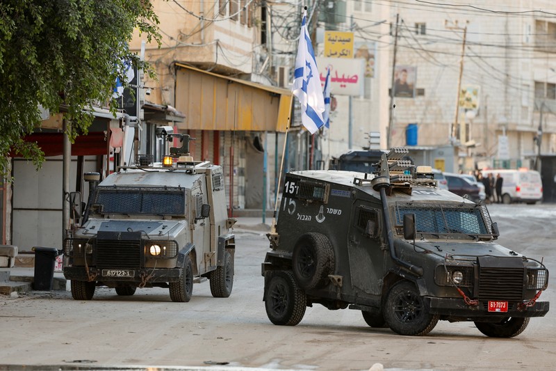 Kendaraan militer Israel melaju di jalan selama serangan Israel, di Jenin, di Tepi Barat yang diduduki Israel, 21 Januari 2025. Kendaraan militer Israel melaju di jalan selama serangan Israel, di Jenin, di Tepi Barat yang diduduki Israel, 21 Januari 2025. (REUTERS/Raneen Sawafta)