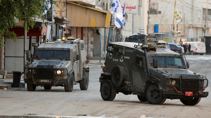 Kendaraan militer Israel melaju di jalan selama serangan Israel, di Jenin, di Tepi Barat yang diduduki Israel, 21 Januari 2025. (REUTERS/Raneen Sawafta)