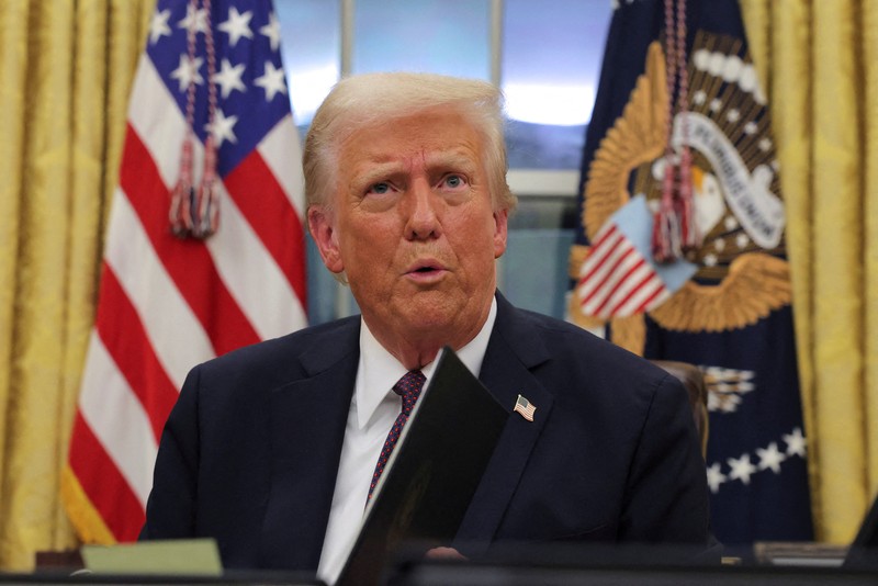 Presiden AS Donald Trump menandatangani dokumen saat mengeluarkan perintah eksekutif dan pengampunan bagi para terdakwa 6 Januari di Ruang Oval di Gedung Putih pada Hari Pelantikan di Washington, AS, 20 Januari 2025. Presiden AS Donald Trump menandatangani dokumen saat mengeluarkan perintah eksekutif dan pengampunan bagi para terdakwa 6 Januari di Ruang Oval di Gedung Putih pada Hari Pelantikan di Washington, AS, 20 Januari 2025. (REUTERS/Carlos Barria)