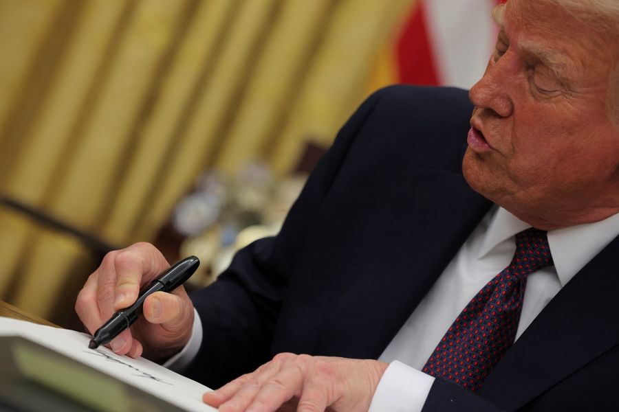 Presiden AS Donald Trump menandatangani dokumen saat mengeluarkan perintah eksekutif dan pengampunan bagi para terdakwa 6 Januari di Ruang Oval di Gedung Putih pada Hari Pelantikan di Washington, AS, 20 Januari 2025.