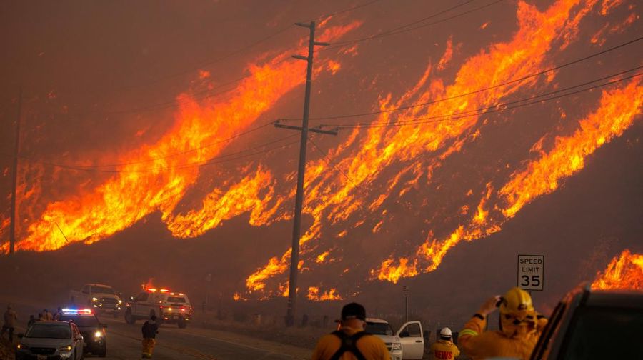 Seorang petugas pemadam kebakaran membawa obor tetes saat ia menyalakan api unggun untuk memadamkan Kebakaran Hughes yang membakar sepanjang lereng bukit di Castaic, California, Rabu, 22 Januari 2025. (AP Photo/Jae C. Hong)