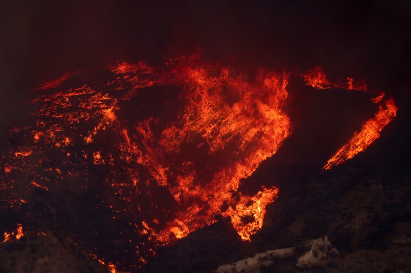 Anggota media bekerja saat asap dan api mengepul saat petugas pemadam kebakaran berjuang memadamkan Kebakaran Hughes di dekat Danau Castaic, utara Santa Clarita, California, AS, 22 Januari 2025. Anggota media bekerja saat asap dan api mengepul saat petugas pemadam kebakaran berjuang memadamkan Kebakaran Hughes di dekat Danau Castaic, utara Santa Clarita, California, AS, 22 Januari 2025. (REUTERS/David Swanson)