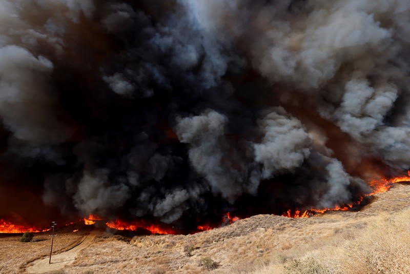 Anggota media bekerja saat asap dan api mengepul saat petugas pemadam kebakaran berjuang memadamkan Kebakaran Hughes di dekat Danau Castaic, utara Santa Clarita, California, AS, 22 Januari 2025. Anggota media bekerja saat asap dan api mengepul saat petugas pemadam kebakaran berjuang memadamkan Kebakaran Hughes di dekat Danau Castaic, utara Santa Clarita, California, AS, 22 Januari 2025. (REUTERS/David Swanson)