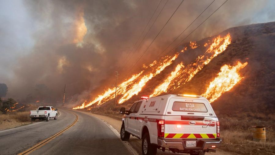 Seorang petugas pemadam kebakaran membawa obor tetes saat ia menyalakan api unggun untuk memadamkan Kebakaran Hughes yang membakar sepanjang lereng bukit di Castaic, California, Rabu, 22 Januari 2025. (AP Photo/Jae C. Hong)