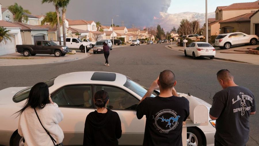 Seorang petugas pemadam kebakaran membawa obor tetes saat ia menyalakan api unggun untuk memadamkan Kebakaran Hughes yang membakar sepanjang lereng bukit di Castaic, California, Rabu, 22 Januari 2025. (AP Photo/Jae C. Hong)