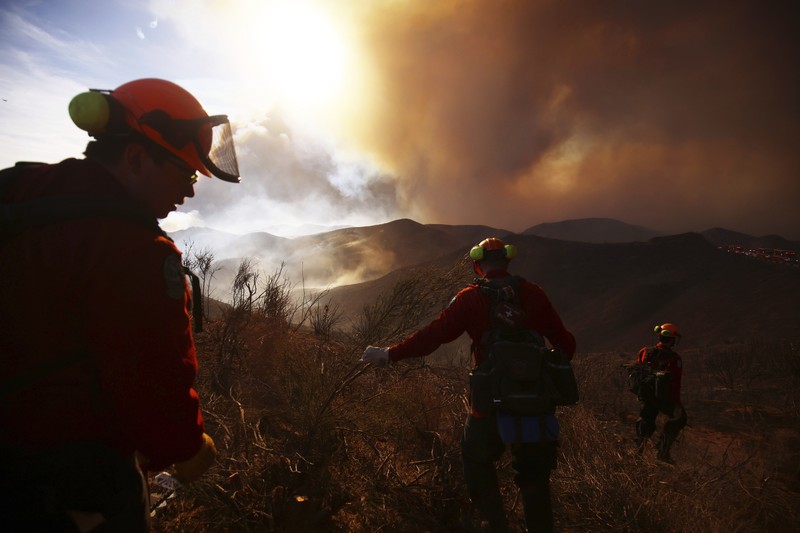 Anggota media bekerja saat asap dan api mengepul saat petugas pemadam kebakaran berjuang memadamkan Kebakaran Hughes di dekat Danau Castaic, utara Santa Clarita, California, AS, 22 Januari 2025. Anggota media bekerja saat asap dan api mengepul saat petugas pemadam kebakaran berjuang memadamkan Kebakaran Hughes di dekat Danau Castaic, utara Santa Clarita, California, AS, 22 Januari 2025. (REUTERS/David Swanson)
