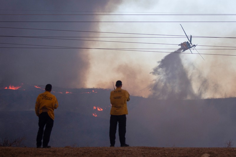 Seorang petugas pemadam kebakaran membawa obor tetes saat ia menyalakan api unggun untuk memadamkan Kebakaran Hughes yang membakar sepanjang lereng bukit di Castaic, California, Rabu, 22 Januari 2025. Seorang petugas pemadam kebakaran membawa obor tetes saat ia menyalakan api unggun untuk memadamkan Kebakaran Hughes yang membakar sepanjang lereng bukit di Castaic, California, Rabu, 22 Januari 2025. (AP Photo/Jae C. Hong)