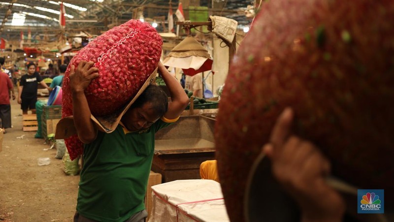 Pekerja melakukan bongkar muat bawang merah dari Brebes, Jawa Tengah di Pasar Kramat Jati, Jakarta, Jumat (24/1/2025). (վ/Tri Susilo)