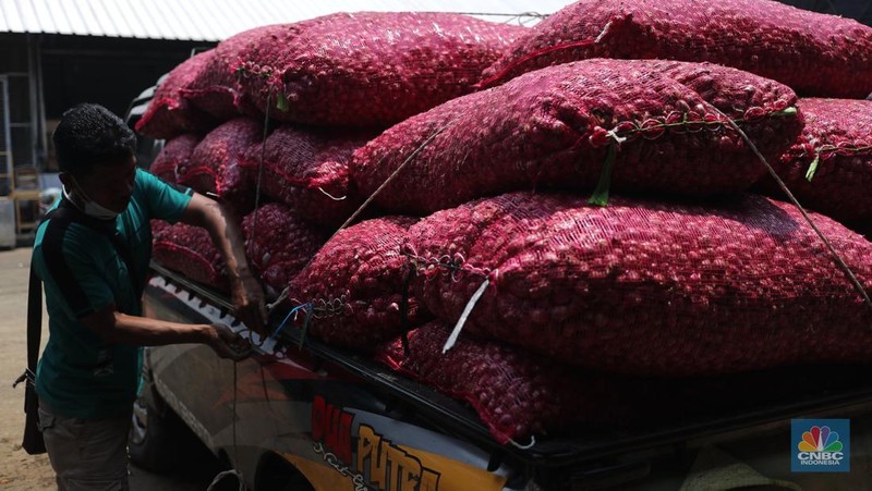 Pekerja melakukan bongkar muat bawang merah dari Brebes, Jawa Tengah di Pasar Kramat Jati, Jakarta, Jumat (24/1/2025). (վ/Tri Susilo)