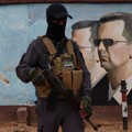 Seorang anggota bekas kelompok pemberontak Hayat Tahrir al-Sham berdiri berjaga di dekat gambar Bashar al-Assad dari Suriah di markas divisi keempat di Damaskus, Suriah, 23 Januari 2025. (REUTERS/Yamam Al Shaar)