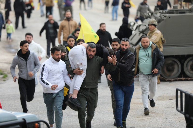 A man carries an injured person in Burj al-Muluk, near the southern Lebanese village of Kfar Kila, where Israeli forces remained on the ground after a deadline for their withdrawal passed as residents sought to return to homes in the border area, Lebanon January 26, 2025. REUTERS/Karamallah Daher