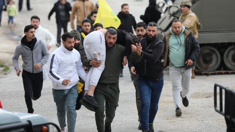 A man carries an injured person in Burj al-Muluk, near the southern Lebanese village of Kfar Kila, where Israeli forces remained on the ground after a deadline for their withdrawal passed as residents sought to return to homes in the border area, Lebanon January 26, 2025. REUTERS/Karamallah Daher