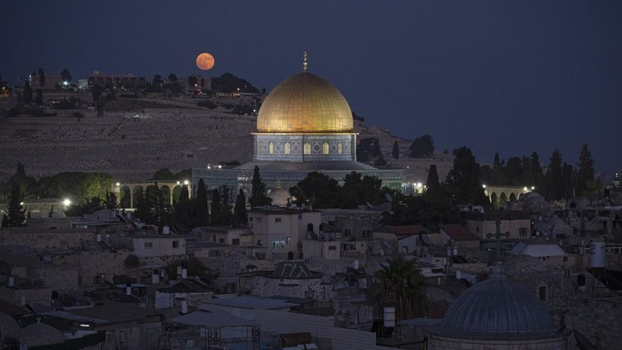 The super moon rises behind the Dome of the Rock shrine at the Al Aqsa Mosque compound in the Old City of Jerusalem, Monday, Aug. 19, 2024. (AP Photo/Leo Correa)