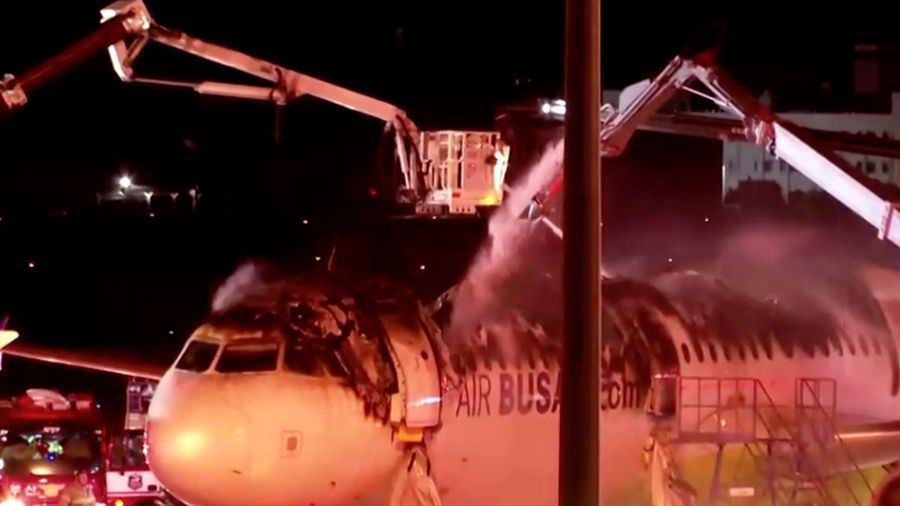 Petugas pemadam kebakaran berupaya memadamkan api pada pesawat Air Busan di Bandara Internasional Gimhae di Busan, Korea Selatan, Selasa (28/1/2025). (Son Hyung-joo/Yonhap via AP)