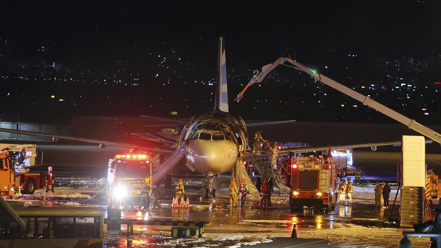 Petugas pemadam kebakaran berupaya memadamkan api pada pesawat Air Busan di Bandara Internasional Gimhae di Busan, Korea Selatan, Selasa (28/1/2025). (Son Hyung-joo/Yonhap via AP)