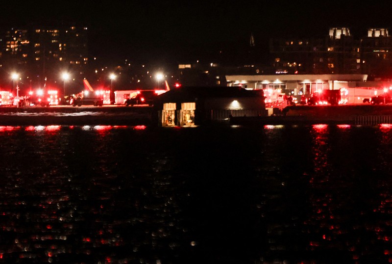 Kendaraan layanan darurat berdiri di dekat lokasi kecelakaan setelah penerbangan American Eagle 5342 bertabrakan dengan helikopter saat mendekati Bandara Nasional Reagan Washington dan jatuh di Sungai Potomac, di luar Washington, AS, 29 Januari 2025. (REUTERS/Carlos Barria)