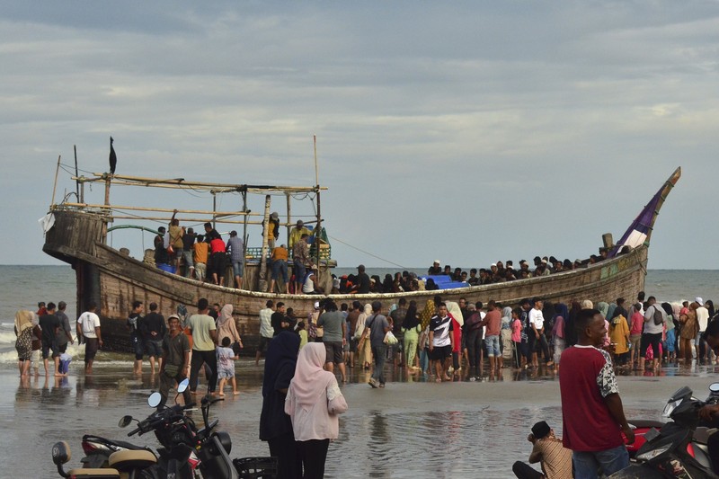 Penduduk setempat memeriksa perahu yang membawa pengungsi Rohingya yang terdampar di pantai di Peureulak, provinsi Aceh, Indonesia, Rabu, 29 Januari 2025. (AP Photo/Husna Mura)