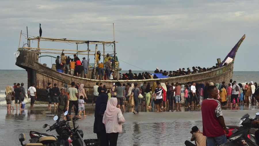 Penduduk setempat memeriksa perahu yang membawa pengungsi Rohingya yang terdampar di pantai di Peureulak, provinsi Aceh, Indonesia, Rabu, 29 Januari 2025. (AP Photo/Husna Mura)