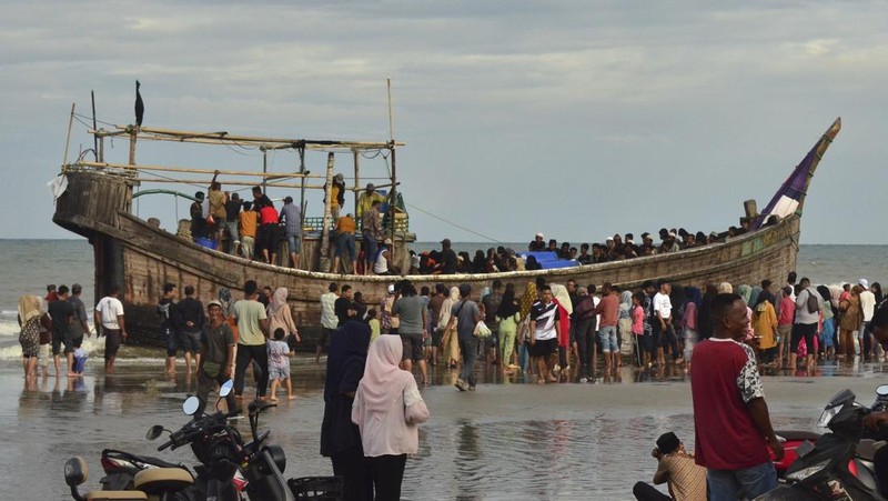 Penduduk setempat memeriksa perahu yang membawa pengungsi Rohingya yang terdampar di pantai di Peureulak, provinsi Aceh, Indonesia, Rabu, 29 Januari 2025. (AP Photo/Husna Mura)