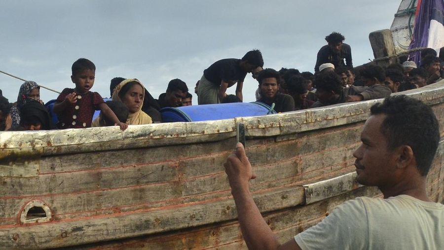 Penduduk setempat memeriksa perahu yang membawa pengungsi Rohingya yang terdampar di pantai di Peureulak, provinsi Aceh, Indonesia, Rabu, 29 Januari 2025. (AP Photo/Husna Mura)