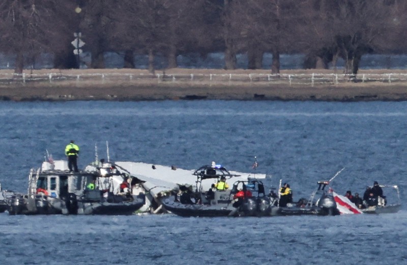 Petugas darurat menemukan puing-puing dari Sungai Potomac setelah tabrakan penerbangan American Eagle 5342 dan helikopter Black Hawk, seperti yang terlihat dari Virginia, AS, 30 Januari 2025. (REUTERS/Carlos Barria)