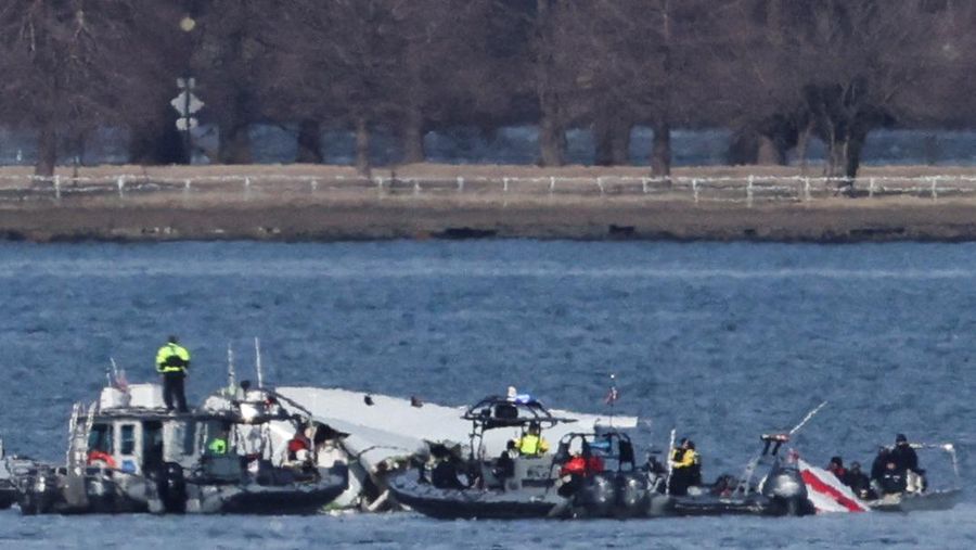 Petugas darurat menemukan puing-puing dari Sungai Potomac setelah tabrakan penerbangan American Eagle 5342 dan helikopter Black Hawk, seperti yang terlihat dari Virginia, AS, 30 Januari 2025. (REUTERS/Carlos Barria)