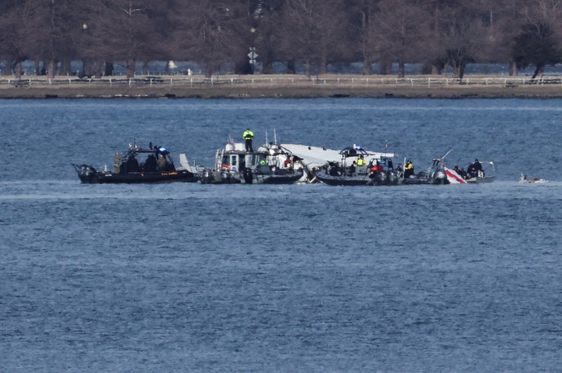 Petugas darurat menemukan puing-puing dari Sungai Potomac setelah tabrakan penerbangan American Eagle 5342 dan helikopter Black Hawk, seperti yang terlihat dari Virginia, AS, 30 Januari 2025. (REUTERS/Carlos Barria)
