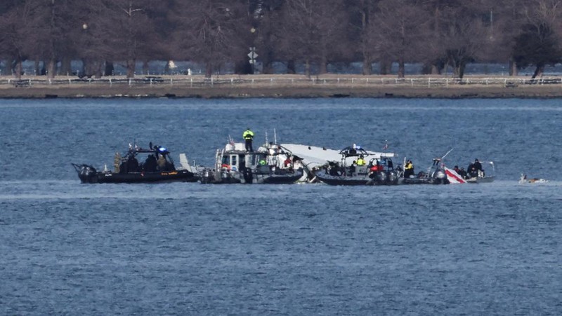Petugas darurat menemukan puing-puing dari Sungai Potomac setelah tabrakan penerbangan American Eagle 5342 dan helikopter Black Hawk, seperti yang terlihat dari Virginia, AS, 30 Januari 2025. (REUTERS/Carlos Barria)
