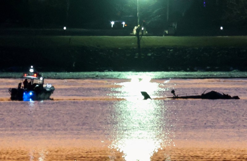 Petugas darurat menemukan puing-puing dari Sungai Potomac setelah tabrakan penerbangan American Eagle 5342 dan helikopter Black Hawk, seperti yang terlihat dari Virginia, AS, 30 Januari 2025. (REUTERS/Carlos Barria)