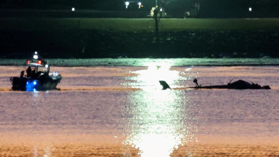 Petugas darurat menemukan puing-puing dari Sungai Potomac setelah tabrakan penerbangan American Eagle 5342 dan helikopter Black Hawk, seperti yang terlihat dari Virginia, AS, 30 Januari 2025. (REUTERS/Carlos Barria)