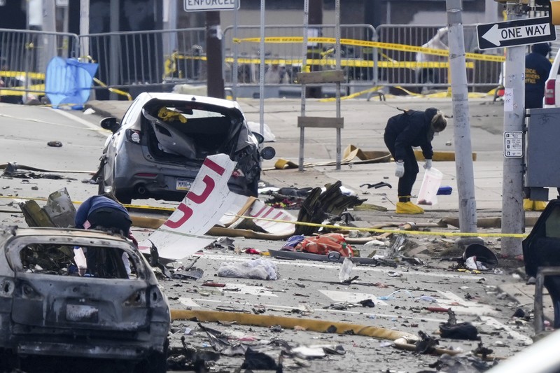 Penyelidik bekerja di tempat kejadian setelah sebuah pesawat kecil jatuh di Philadelphia, Sabtu, 1 Februari 2025. (AP Photo/Matt Rourke)