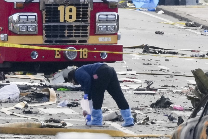 Penyelidik bekerja di tempat kejadian setelah sebuah pesawat kecil jatuh di Philadelphia, Sabtu, 1 Februari 2025. (AP Photo/Matt Rourke)