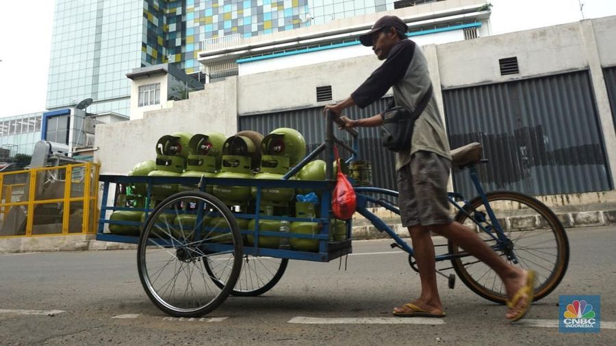 Pekerja mendorong gerobak bermuatan tabung gas LPG 3kg yang akan didistribusikan ke warung eceran di kawasan Mangga Besar, Jakarta, Selasa (4/2/2025). (վ/Muhammad Sabki)