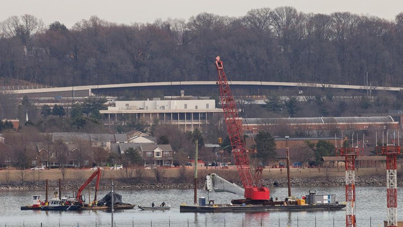 Petugas mengoperasikan alat berat untuk mengangkat sisa-sisa pesawat pasca kecelakaan pesawat American Airlines penerbangan 5342 dan helikopter Black Hawk di Sungai Potomac, Washington DC, Amerika Serikat, Senin (3/2/2024) waktu setempat. (REUTERS/Eduardo Munoz)
