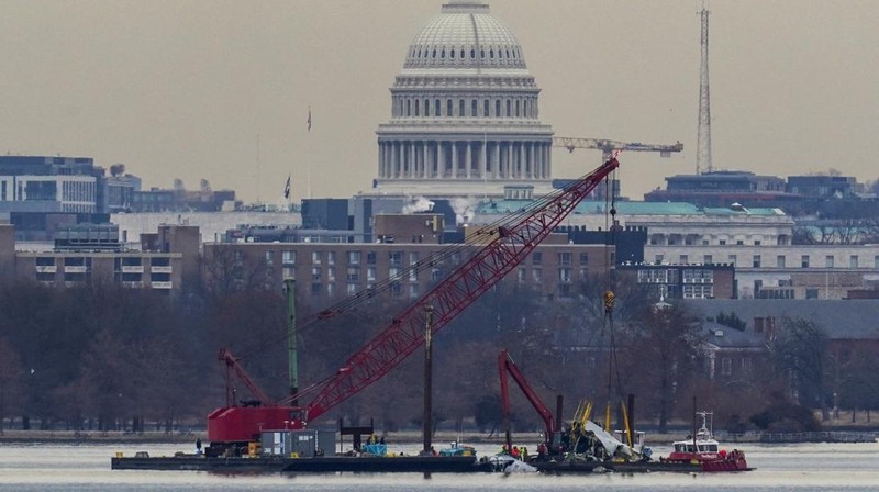 Petugas mengoperasikan alat berat untuk mengangkat sisa-sisa pesawat pasca kecelakaan pesawat American Airlines penerbangan 5342 dan helikopter Black Hawk di Sungai Potomac, Washington DC, Amerika Serikat, Senin (3/2/2024) waktu setempat. (REUTERS/Eduardo Munoz)