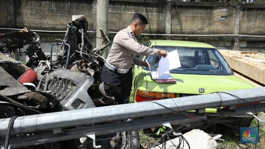 Petugas memeriksa bangkai kendaraan yang terbakar dalam kecelakaan di Gerbang Tol Ciawi kini berada di Kantor PJR Ciawi, Rabu (5/2/2025). (CNBC Indonesia/Tri Susilo)