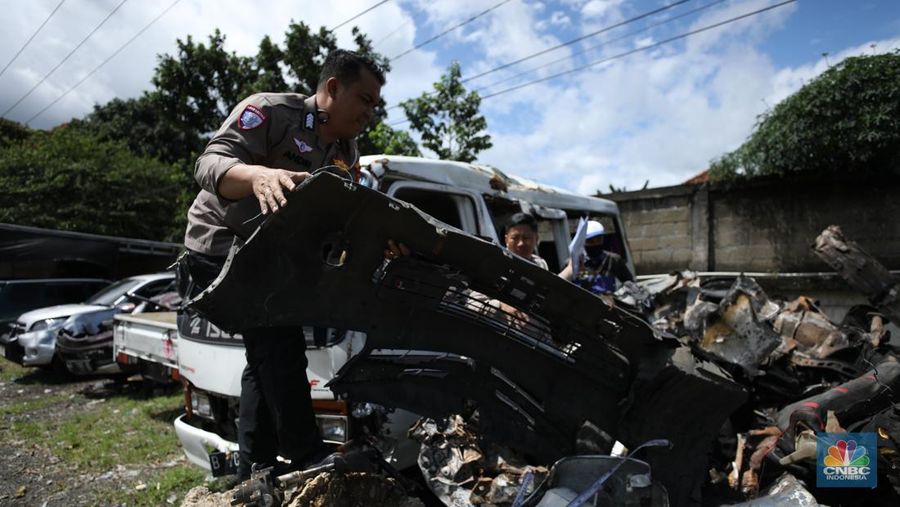 Petugas memeriksa bangkai kendaraan yang terbakar dalam kecelakaan di Gerbang Tol Ciawi kini berada di Kantor PJR Ciawi, Rabu (5/2/2025). (CNBC Indonesia/Tri Susilo)