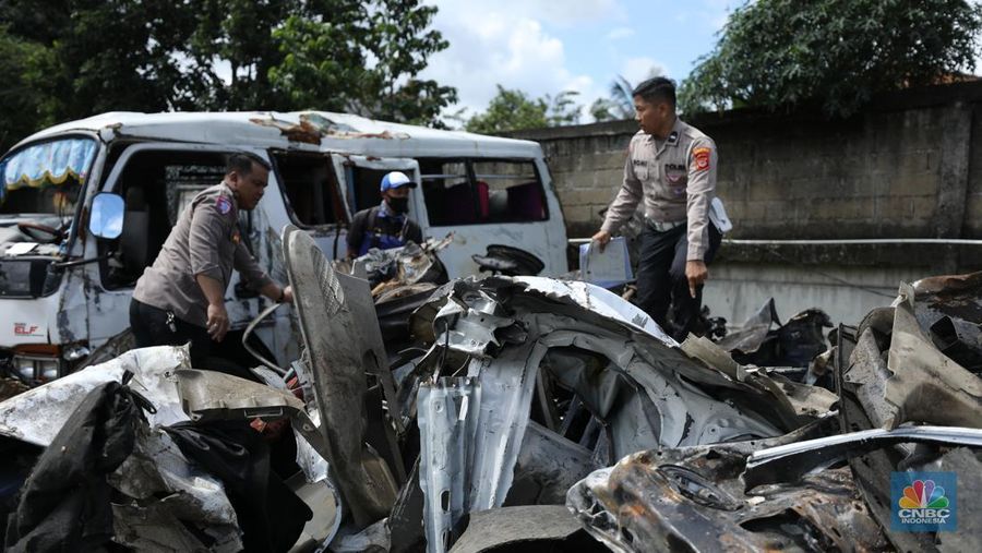 Petugas memeriksa bangkai kendaraan yang terbakar dalam kecelakaan di Gerbang Tol Ciawi kini berada di Kantor PJR Ciawi, Rabu (5/2/2025). (CNBC Indonesia/Tri Susilo)