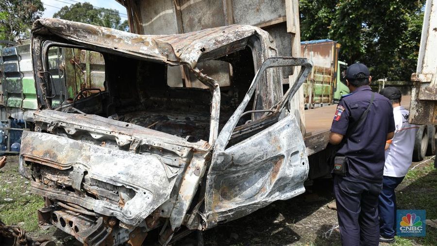 Petugas memeriksa bangkai kendaraan yang terbakar dalam kecelakaan di Gerbang Tol Ciawi kini berada di Kantor PJR Ciawi, Rabu (5/2/2025). (CNBC Indonesia/Tri Susilo)