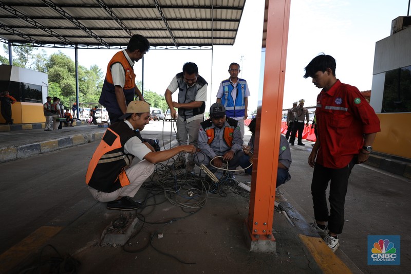 Suasana pekerja melakukan pembersihan  setelah kecelakaan beruntun di Gerbang Tol (GT) Ciawi 2, Bogor. Sebanyak 3 gardu di GT Ciawi 2 mengalami kerusakan, Rabu (5/2/2025). (CNBC Indonesia/Tri Susilo)