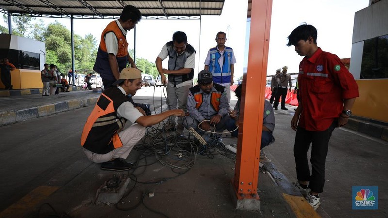 Suasana pekerja melakukan pembersihan  setelah kecelakaan beruntun di Gerbang Tol (GT) Ciawi 2, Bogor. Sebanyak 3 gardu di GT Ciawi 2 mengalami kerusakan, Rabu (5/2/2025). (CNBC Indonesia/Tri Susilo)