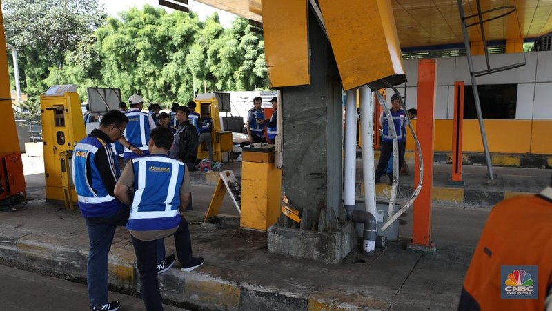 Suasana pekerja melakukan pembersihan  setelah kecelakaan beruntun di Gerbang Tol (GT) Ciawi 2, Bogor. Sebanyak 3 gardu di GT Ciawi 2 mengalami kerusakan, Rabu (5/2/2025). (CNBC Indonesia/Tri Susilo)