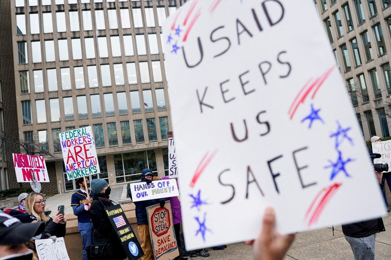 Para demonstran berunjuk rasa selama protes terhadap Presiden AS Donald Trump dan tindakan yang diambilnya pada minggu-minggu pertama masa jabatannya, di luar Departemen Tenaga Kerja (tidak terlihat) di Washington, AS, 5 Februari 2025. Para demonstran berunjuk rasa selama protes terhadap Presiden AS Donald Trump dan tindakan yang diambilnya pada minggu-minggu pertama masa jabatannya, di luar Departemen Tenaga Kerja (tidak terlihat) di Washington, AS, 5 Februari 2025. (REUTERS/Nathan Howard)