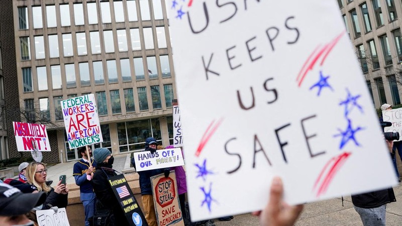Para demonstran berunjuk rasa selama protes terhadap Presiden AS Donald Trump dan tindakan yang diambilnya pada minggu-minggu pertama masa jabatannya, di luar Departemen Tenaga Kerja (tidak terlihat) di Washington, AS, 5 Februari 2025. (REUTERS/Nathan Howard)