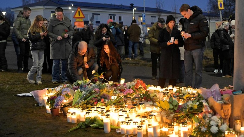 Para pelayat berkumpul untuk meletakkan bunga dan lilin di luar Sekolah Risbergska di Orebro sehari setelah penembakan di sekolah yang menewaskan lebih dari 10 orang, di Swedia 5 Februari 2025. (TT News Agency/Anders Wiklund via REUTERS)