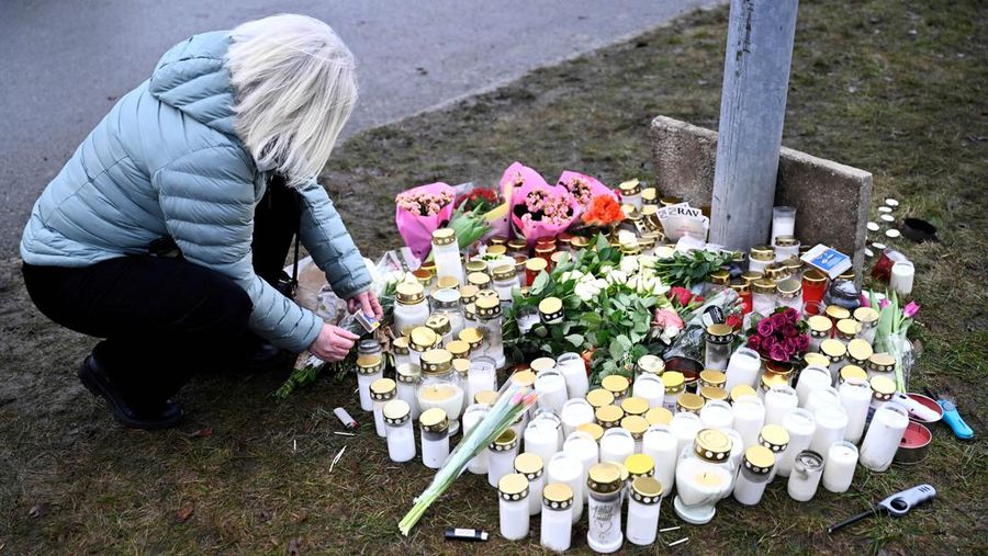 Para pelayat berkumpul untuk meletakkan bunga dan lilin di luar Sekolah Risbergska di Orebro sehari setelah penembakan di sekolah yang menewaskan lebih dari 10 orang, di Swedia 5 Februari 2025. (TT News Agency/Anders Wiklund via REUTERS)