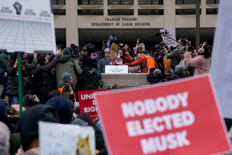 Para demonstran berunjuk rasa selama protes terhadap Presiden AS Donald Trump dan tindakan yang diambilnya pada minggu-minggu pertama masa jabatannya, di luar Departemen Tenaga Kerja (tidak terlihat) di Washington, AS, 5 Februari 2025. (REUTERS/Nathan Howard)