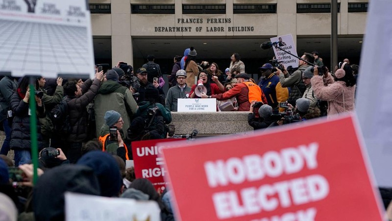 Para demonstran berunjuk rasa selama protes terhadap Presiden AS Donald Trump dan tindakan yang diambilnya pada minggu-minggu pertama masa jabatannya, di luar Departemen Tenaga Kerja (tidak terlihat) di Washington, AS, 5 Februari 2025. (REUTERS/Nathan Howard)