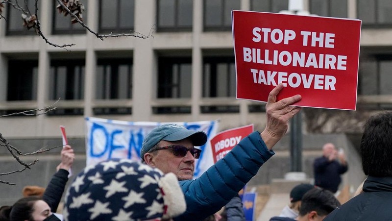 Para demonstran berunjuk rasa selama protes terhadap Presiden AS Donald Trump dan tindakan yang diambilnya pada minggu-minggu pertama masa jabatannya, di luar Departemen Tenaga Kerja (tidak terlihat) di Washington, AS, 5 Februari 2025. (REUTERS/Nathan Howard)