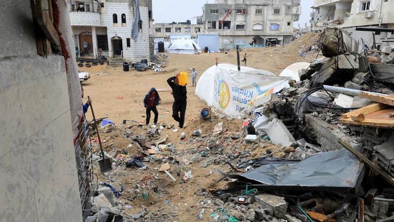 Seorang warga Palestina membawa air di tengah gencatan senjata antara Israel dan Hamas, di kamp pengungsi Jabalia di Jalur Gaza utara, 4 Februari 2025. (REUTERS/Mahmoud Issa)